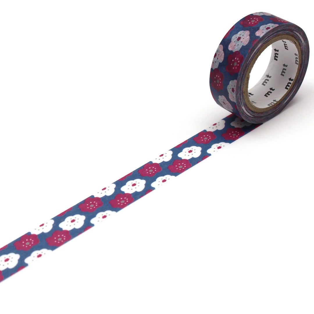 A roll of washi tape with a navy blue background and a pattern of white flowers and leaves.