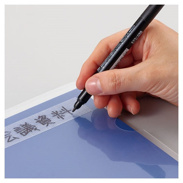 Hand holding a black pen writing on a blue document with text.