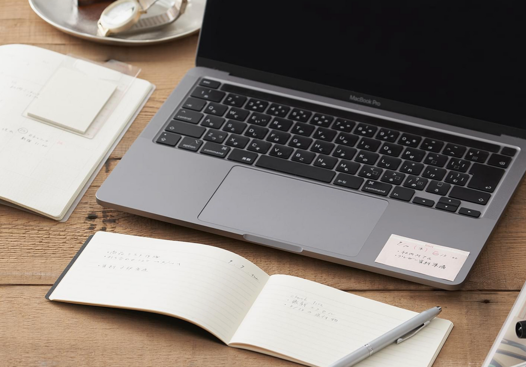 The Isshoni Laptop Notebook - Grid is a rectangular notebook with a faint grid, shown horizontally and featuring a vertical fold line. Unmarked and made in Japan, its perfect for desktop notebooks or 13 laptops.