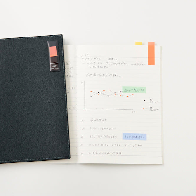Black notebook and open planner with colorful stickers on a white background