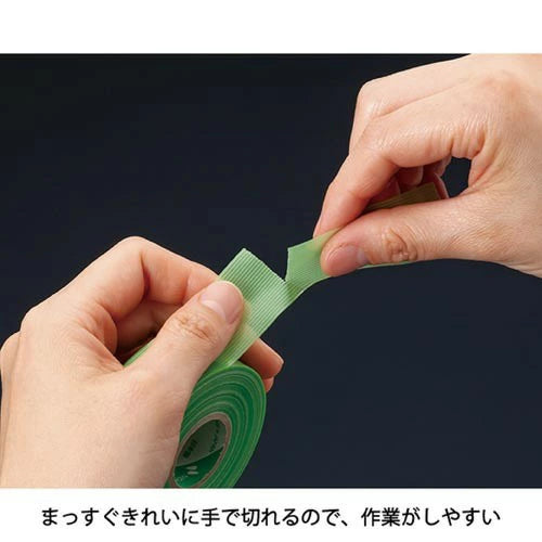 Hands holding a roll of green tape against a black background