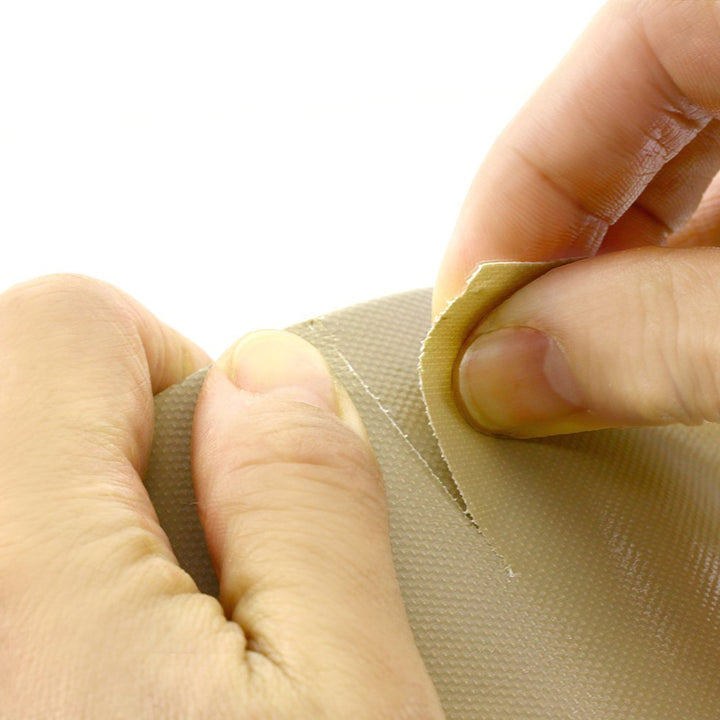 Person applying a small piece of tape to a surface