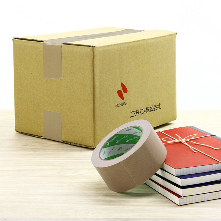 Cardboard box with tape and notebooks on a light surface