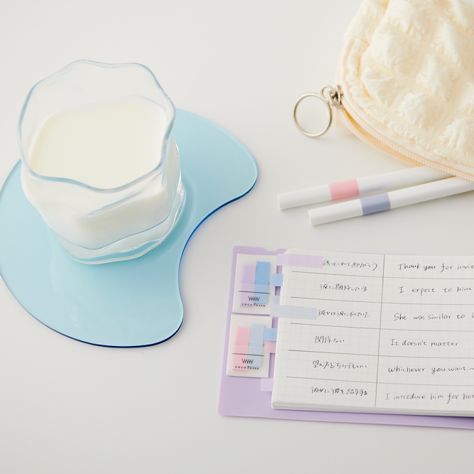 Notebook with to-do list, glass of milk, and pouch on a white surface