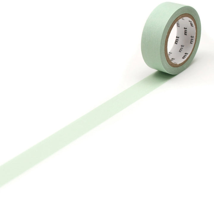 Roll of light green tape with a white label on a white background
