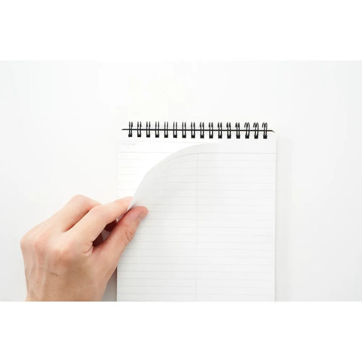 Hand holding a spiral-bound notebook on a white background #paper-type_7mm-lined