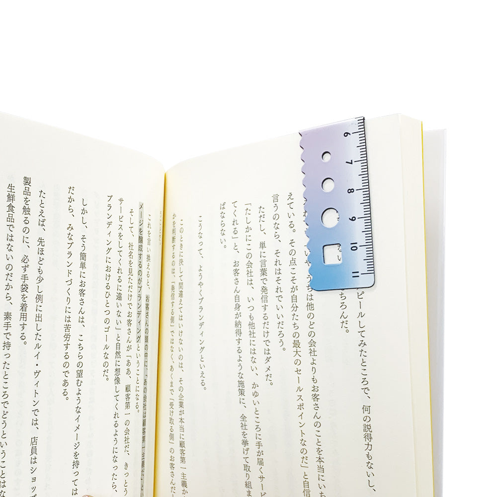 Kyoei gradient magnetic bookmark in pink to blue, folded over a book page as a page marker #colour_pink-to-blue