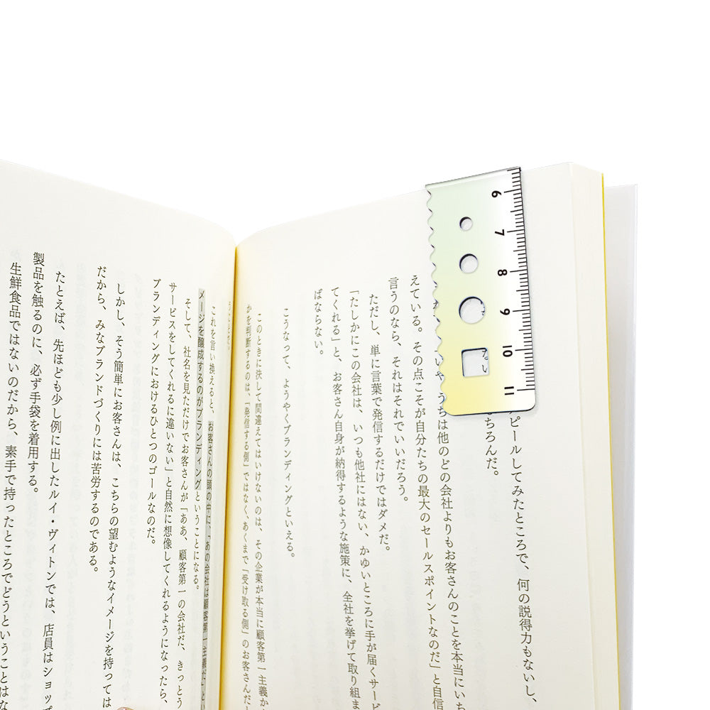 Kyoei gradient magnetic bookmark in green to yellow, folded over a book page as a page marker #colour_green-to-yellow