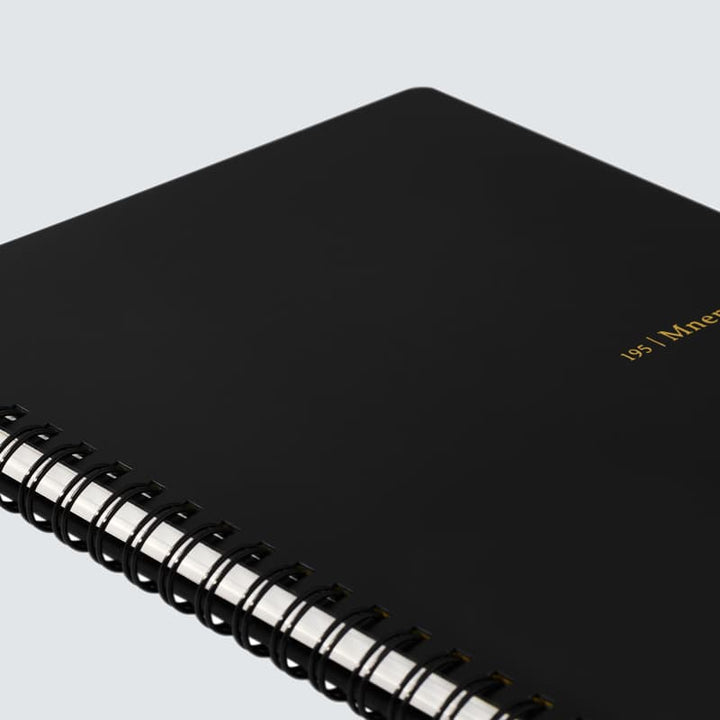 Black spiral-bound notebook on a light gray background

#paper-size_a5